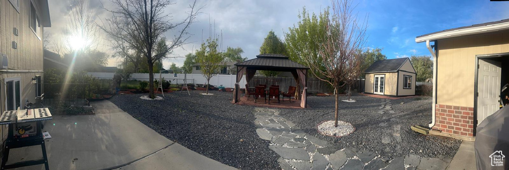 View of patio with a gazebo, a fenced backyard, and an outdoor structure