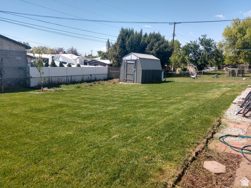 View of yard featuring a storage unit and an outbuilding