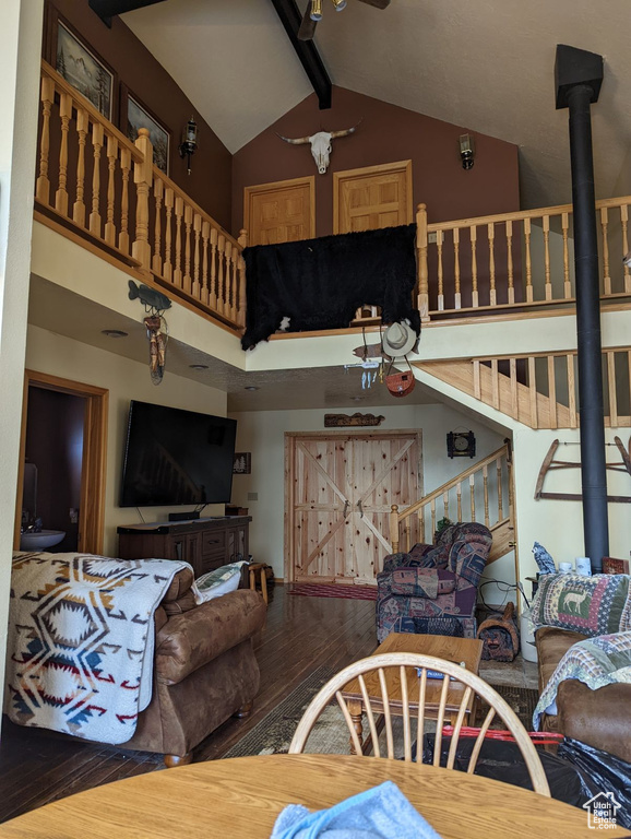 Living area featuring high vaulted ceiling, wood finished floors, beamed ceiling, and a ceiling fan