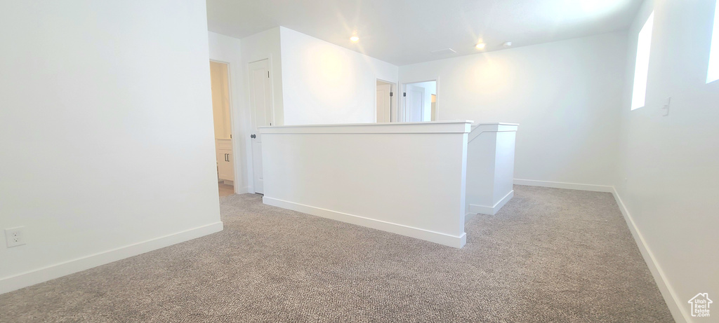 Spare room featuring light colored carpet, baseboards, and recessed lighting