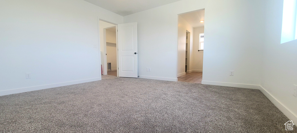 Unfurnished bedroom with carpet floors and baseboards