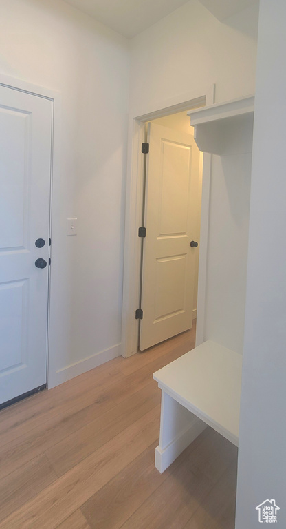 Mudroom with light wood finished floors and baseboards