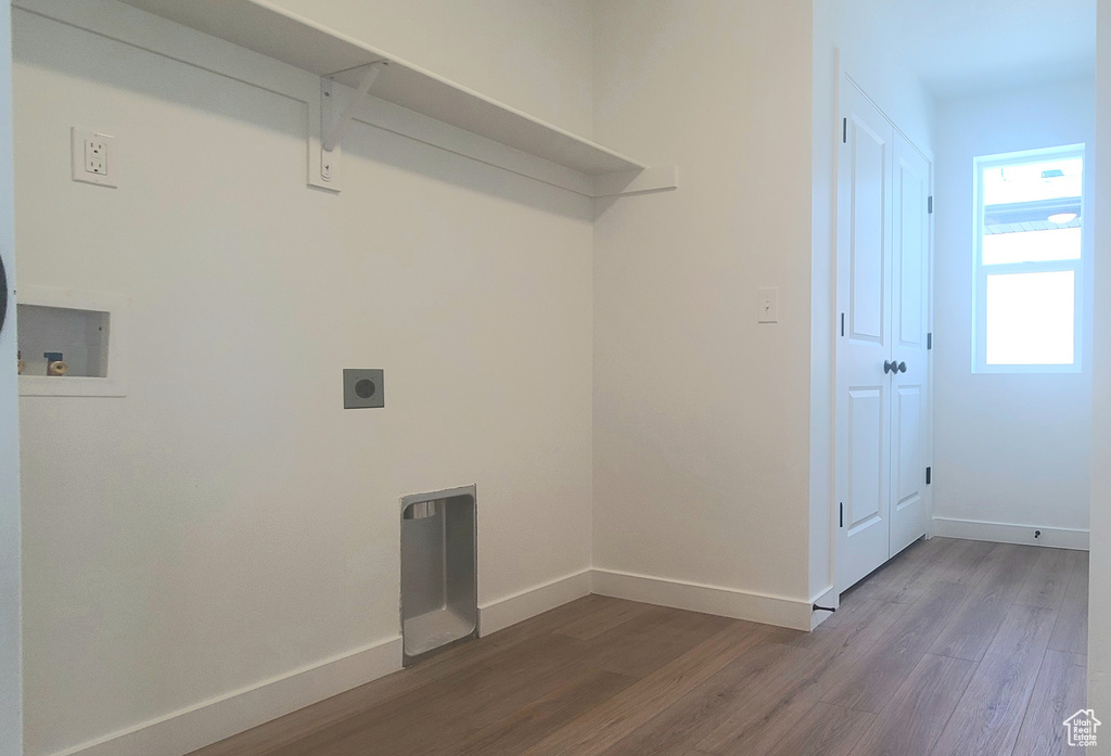Laundry area featuring hookup for an electric dryer, wood finished floors, and baseboards