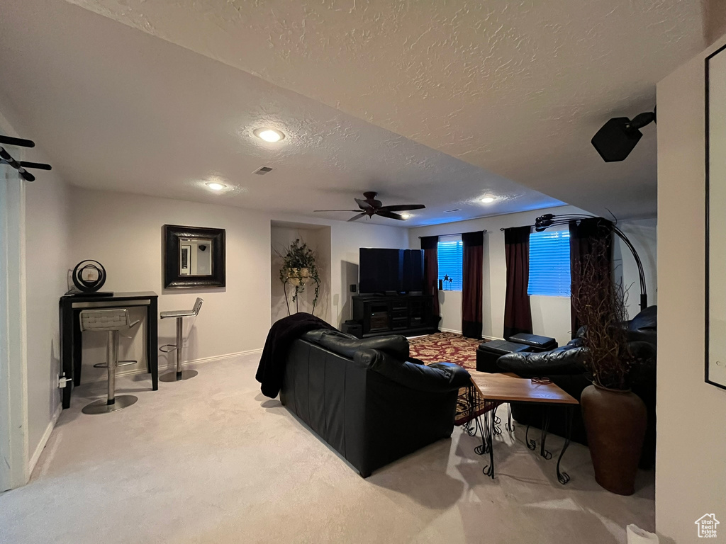 Living area featuring a textured ceiling, baseboards, ceiling fan, carpet flooring, and recessed lighting