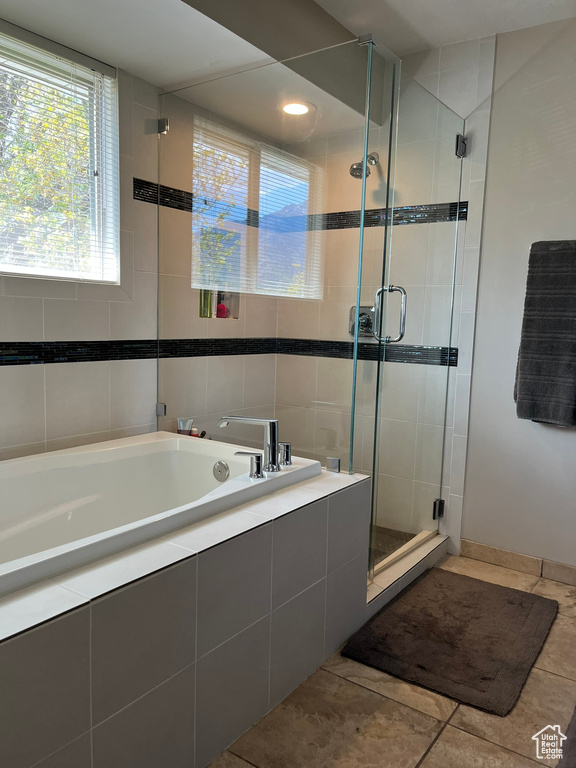 Full bath featuring a shower stall, tile patterned floors, a garden tub, and tile walls