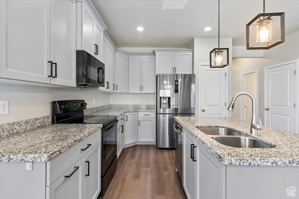 Kitchen featuring black appliances, a sink, dark wood-style flooring, recessed lighting, and pendant lighting