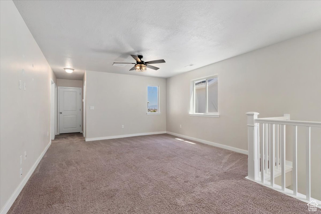 Empty room featuring a ceiling fan, carpet floors, and baseboards
