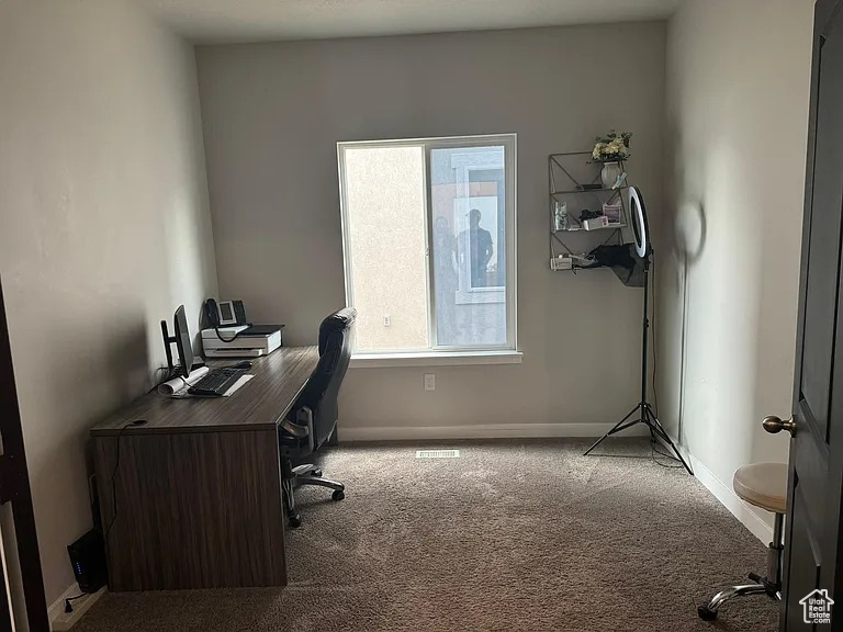 Carpeted office space with baseboards
