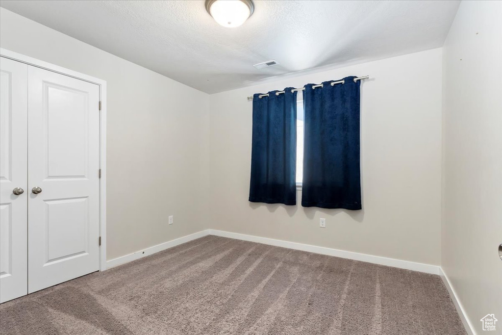 Carpeted spare room with baseboards