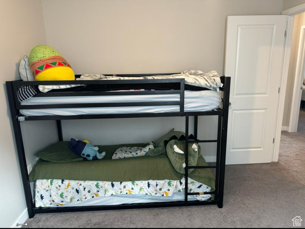 Bedroom featuring carpet and baseboards