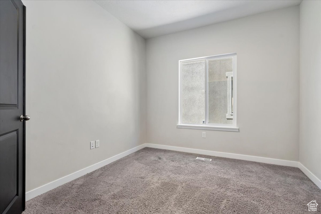 Carpeted empty room with baseboards