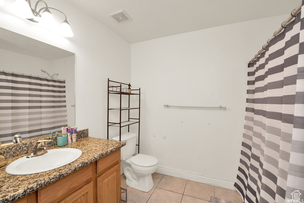 Full bath with tile patterned flooring, toilet, vanity, and curtained shower