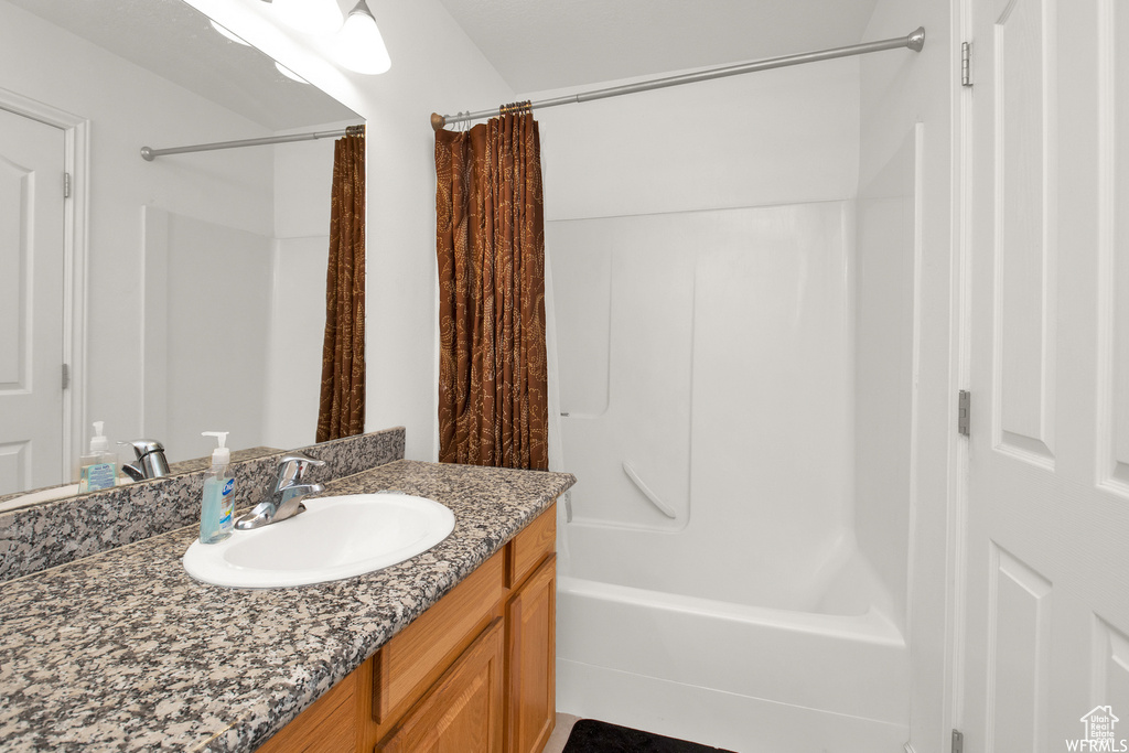 Full bathroom with shower / tub combo with curtain and vanity