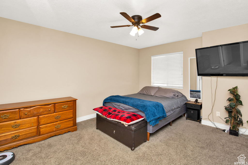 Carpeted bedroom featuring baseboards and a ceiling fan