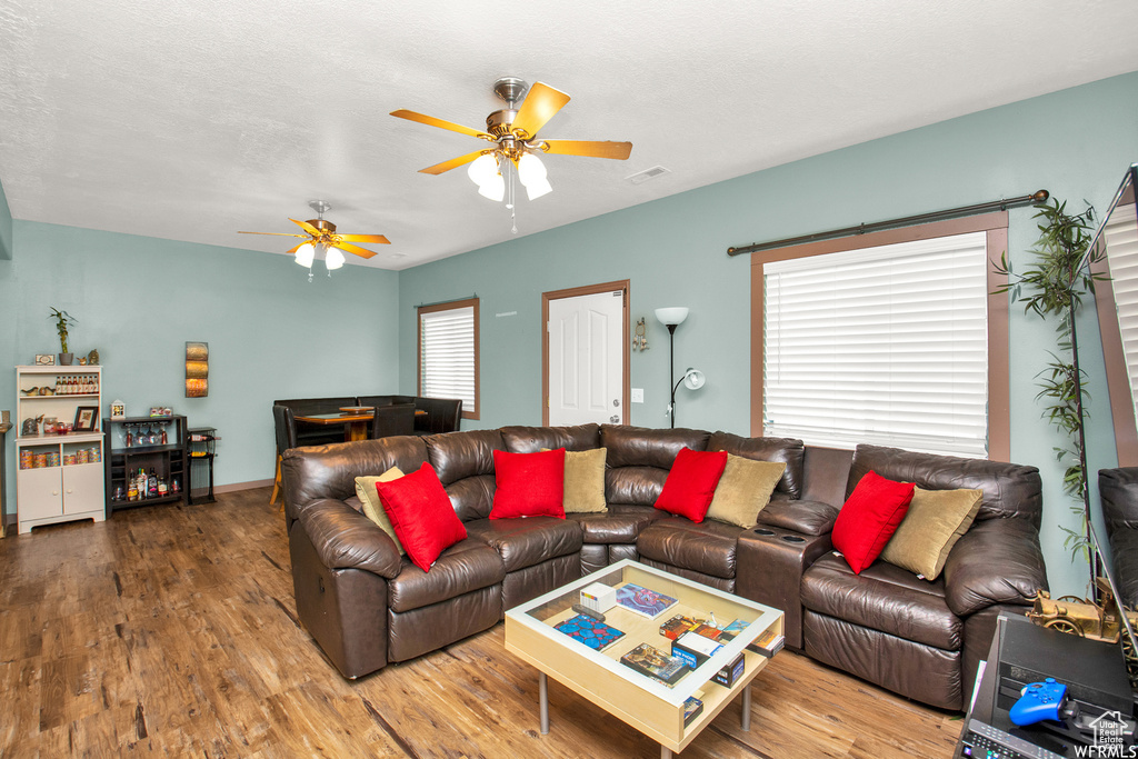 Living area featuring wood finished floors and ceiling fan