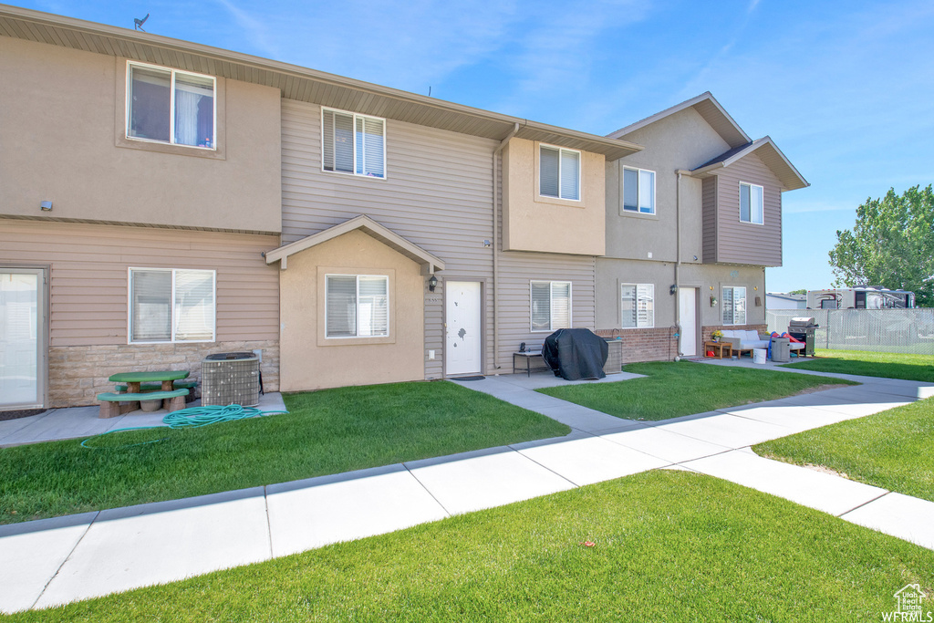 Back of house featuring a patio, stucco siding, cooling unit, and stone siding