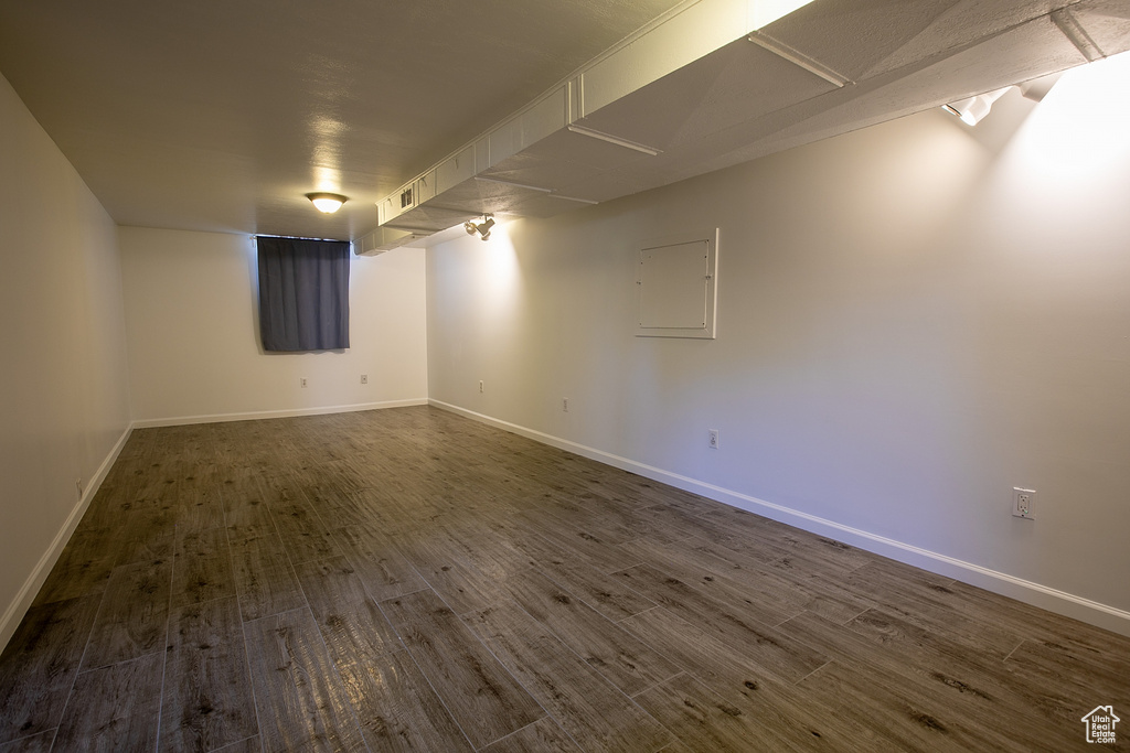 Finished basement featuring dark wood finished floors and baseboards