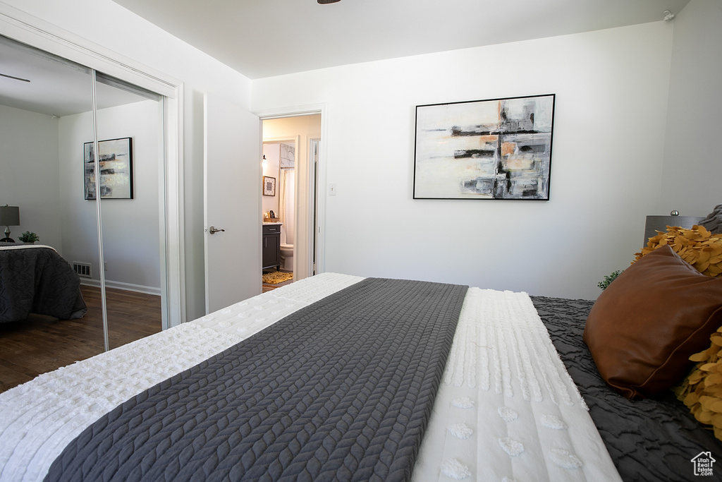 Bedroom with wood finished floors, a closet, and baseboards