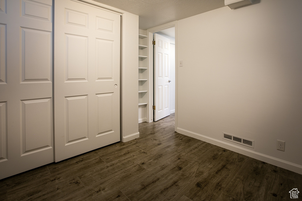 Unfurnished bedroom with dark wood finished floors and baseboards