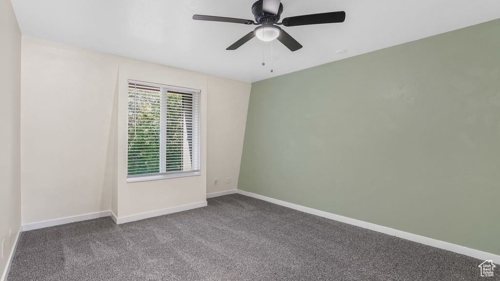 Unfurnished room with ceiling fan, baseboards, and carpet flooring