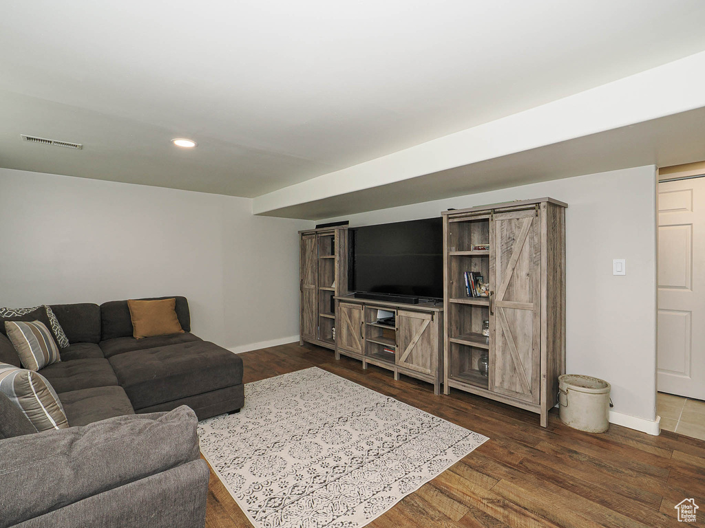 Living area featuring baseboards, dark wood-type flooring, and recessed lighting