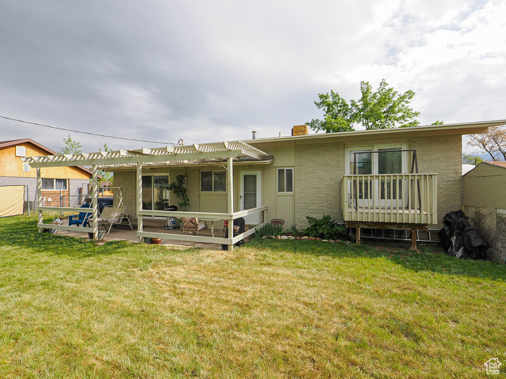 Back of house featuring a pergola, a patio area, and a yard