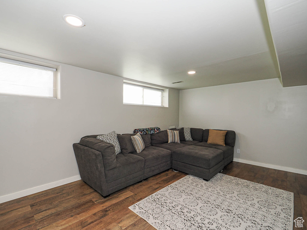 Living room featuring dark wood-style floors, baseboards, and recessed lighting