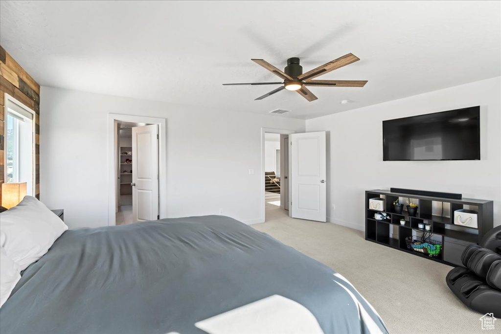 Bedroom featuring light carpet, baseboards, and ceiling fan