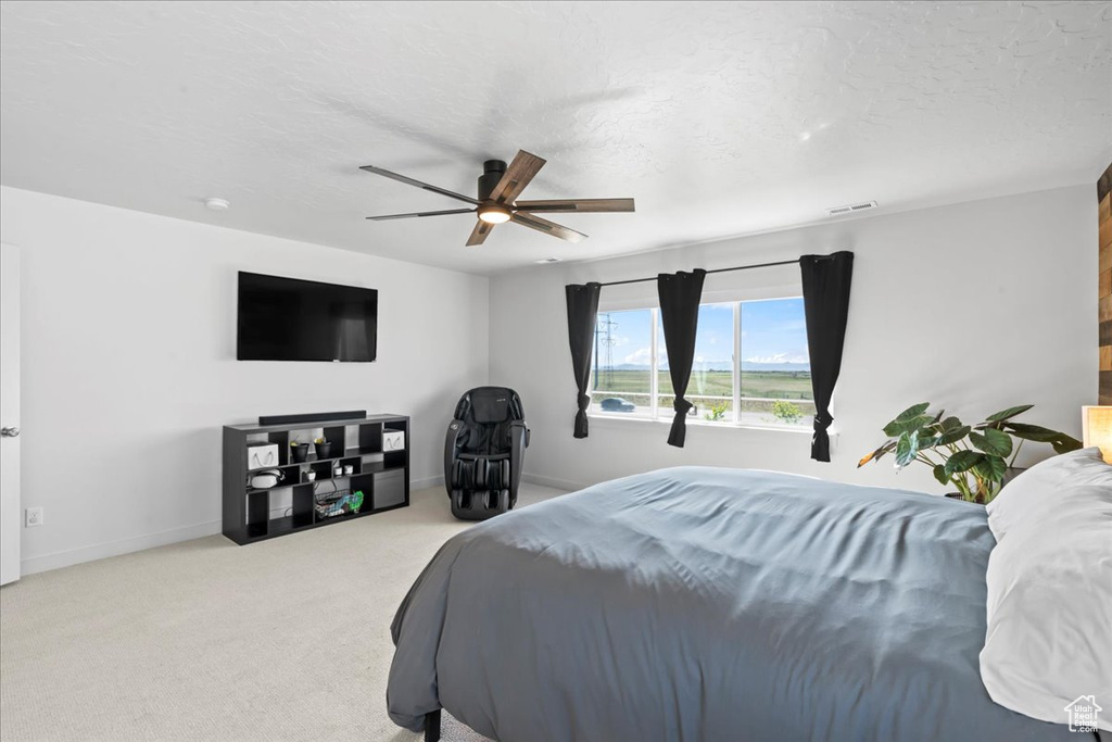 Carpeted bedroom with ceiling fan and baseboards