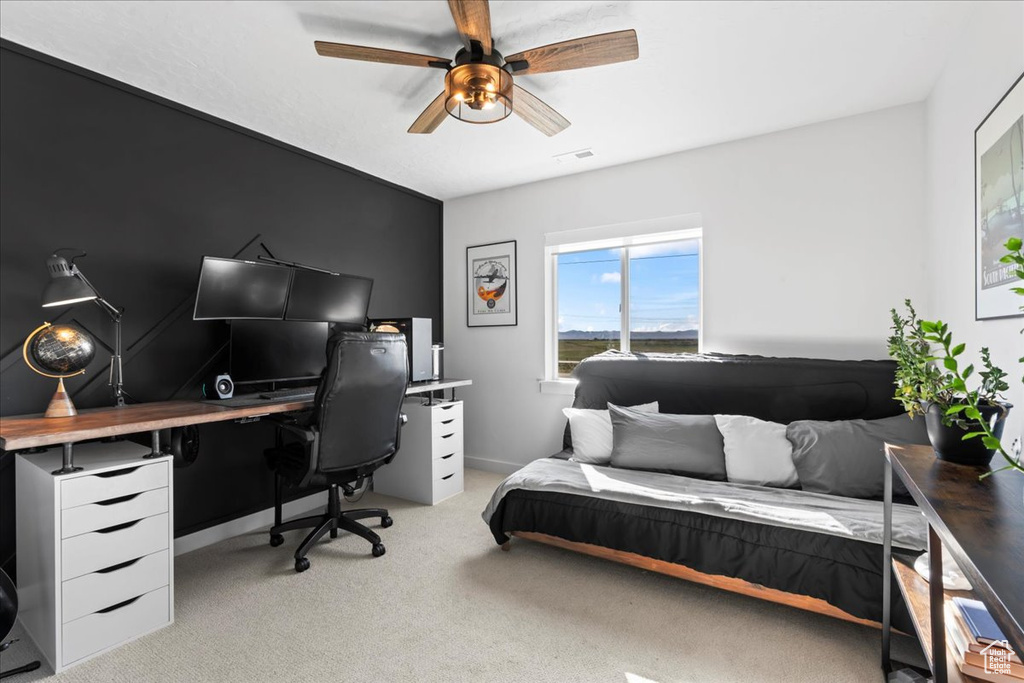 Bedroom with a desk, light carpet, and ceiling fan
