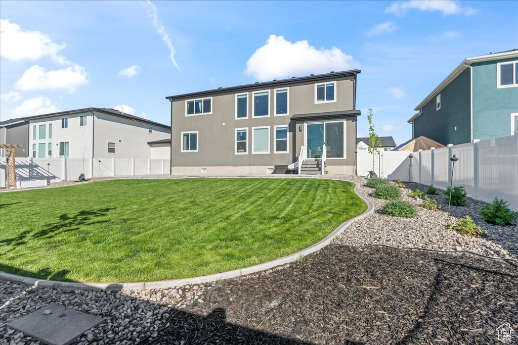 Rear view of house featuring entry steps and stucco siding
