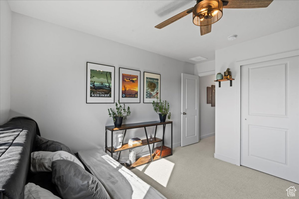 Bedroom with light carpet and a ceiling fan
