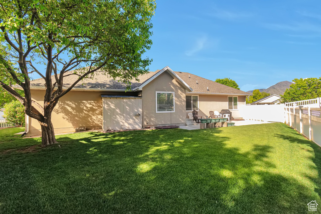Back of property featuring stucco siding, roof with shingles, and a patio