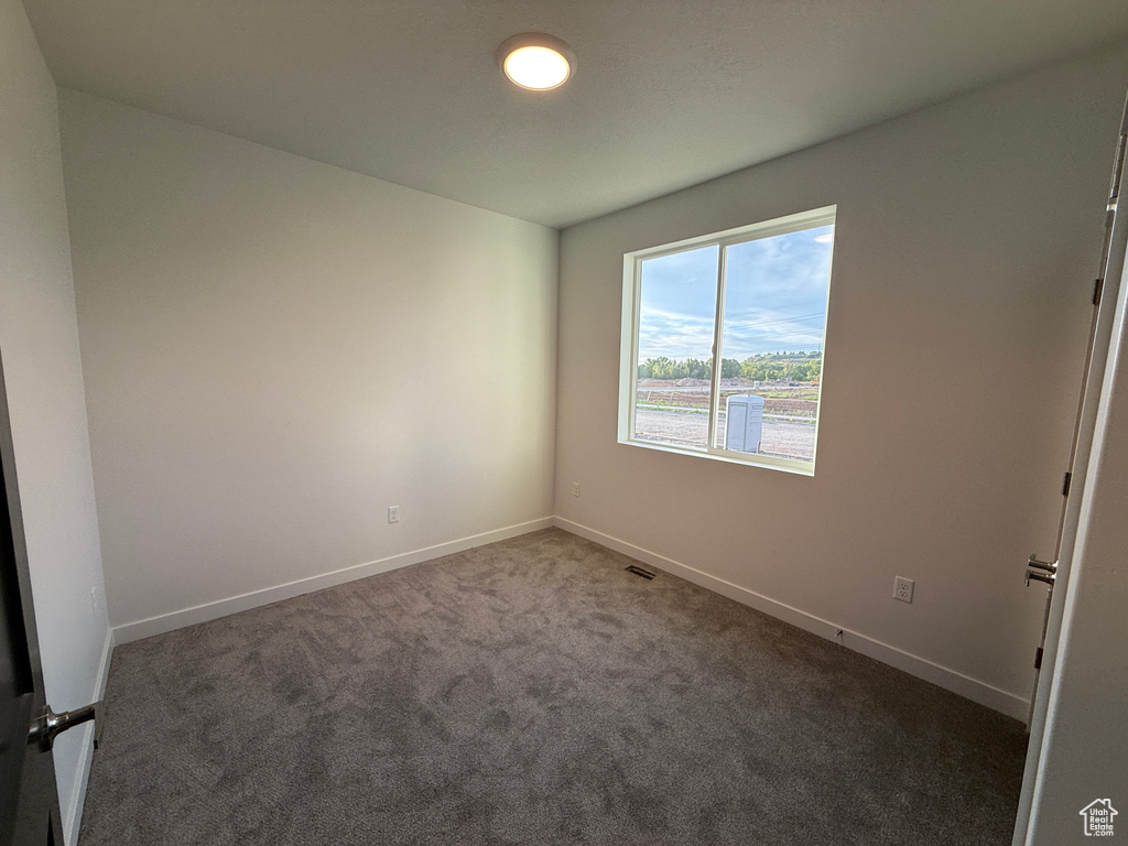 Spare room featuring carpet and baseboards
