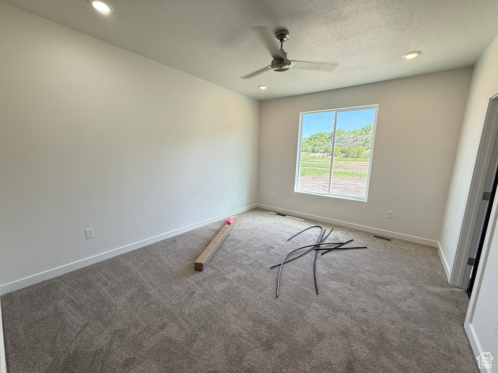 Carpeted spare room featuring ceiling fan, baseboards, a textured ceiling, and recessed lighting
