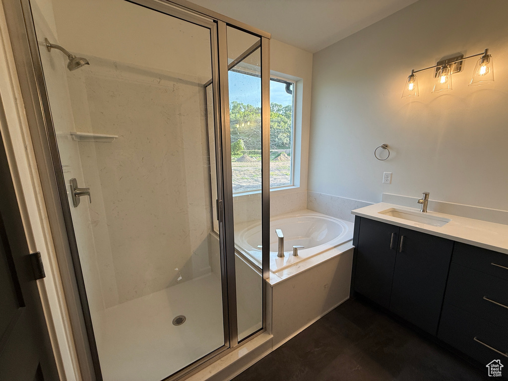 Bathroom featuring a bath, a shower stall, and vanity