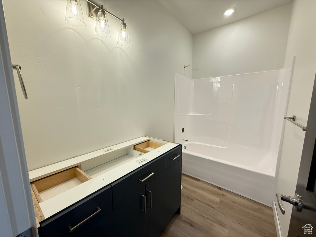 Full bath with wood finished floors, recessed lighting, and  shower combination