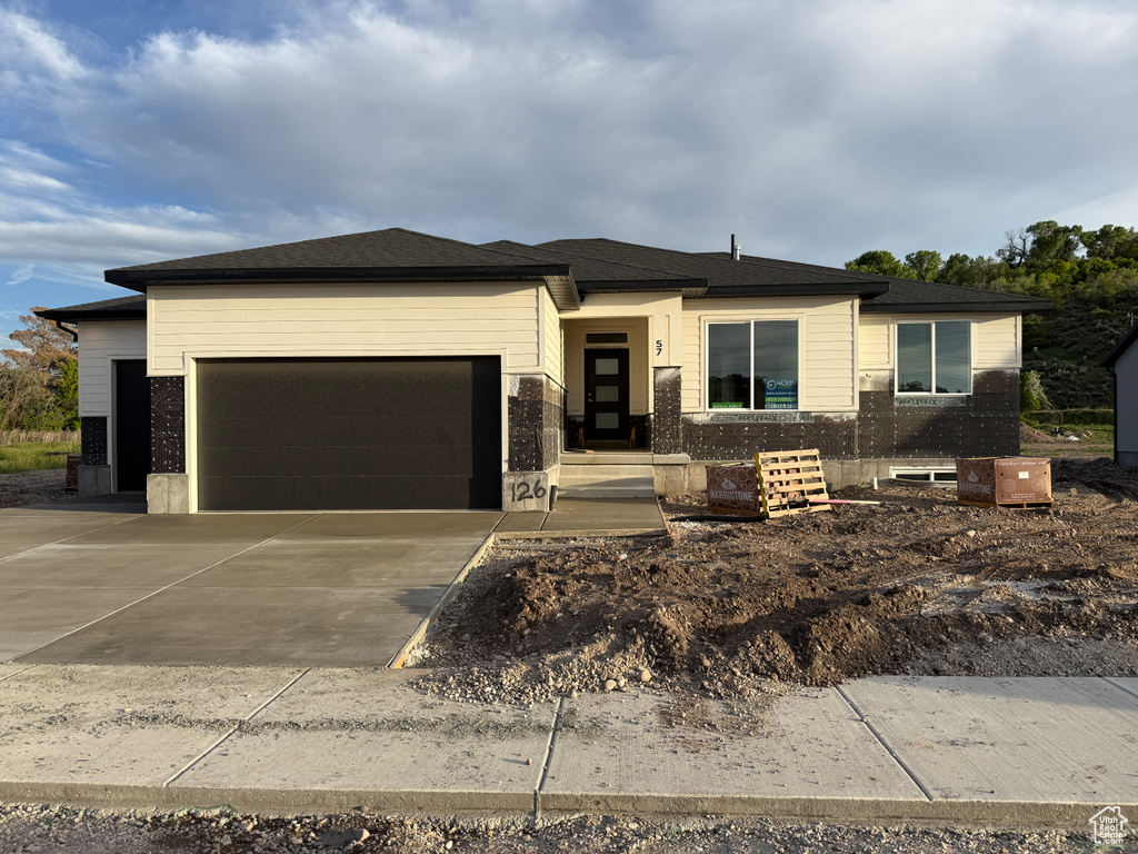 Prairie-style home featuring an attached garage and driveway