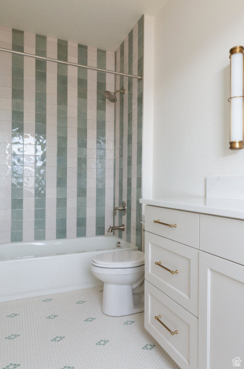 Bathroom with toilet,  shower combination, vanity, and tile patterned floors