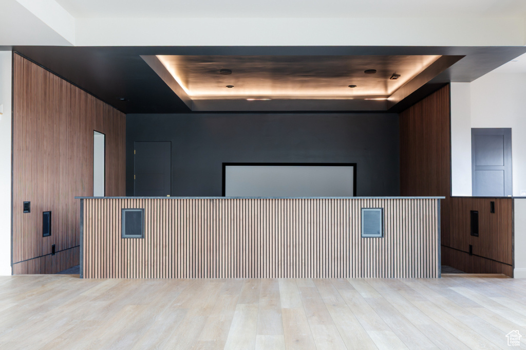 Spare room featuring a tray ceiling, wood finished floors, and wood walls