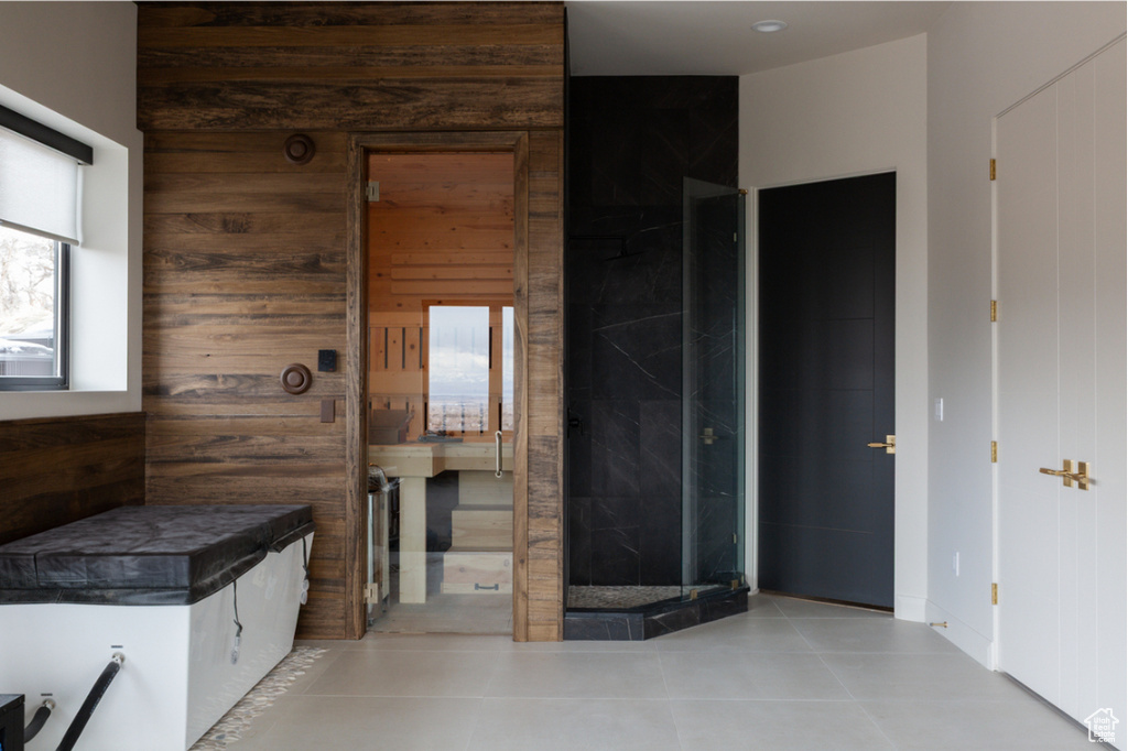 Bathroom featuring wood walls and tile patterned floors