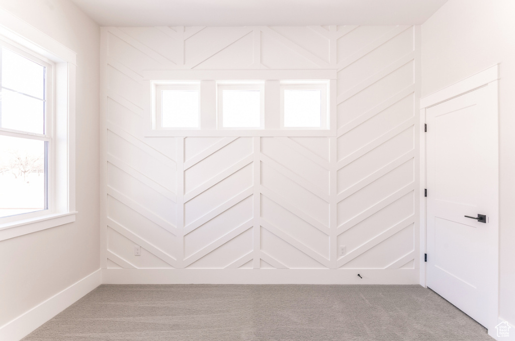 Empty room with light carpet and baseboards