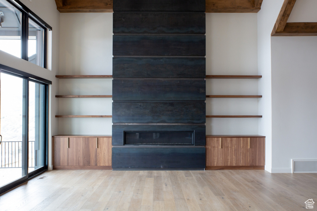 Unfurnished living room with a fireplace, light wood-style flooring, and plenty of natural light