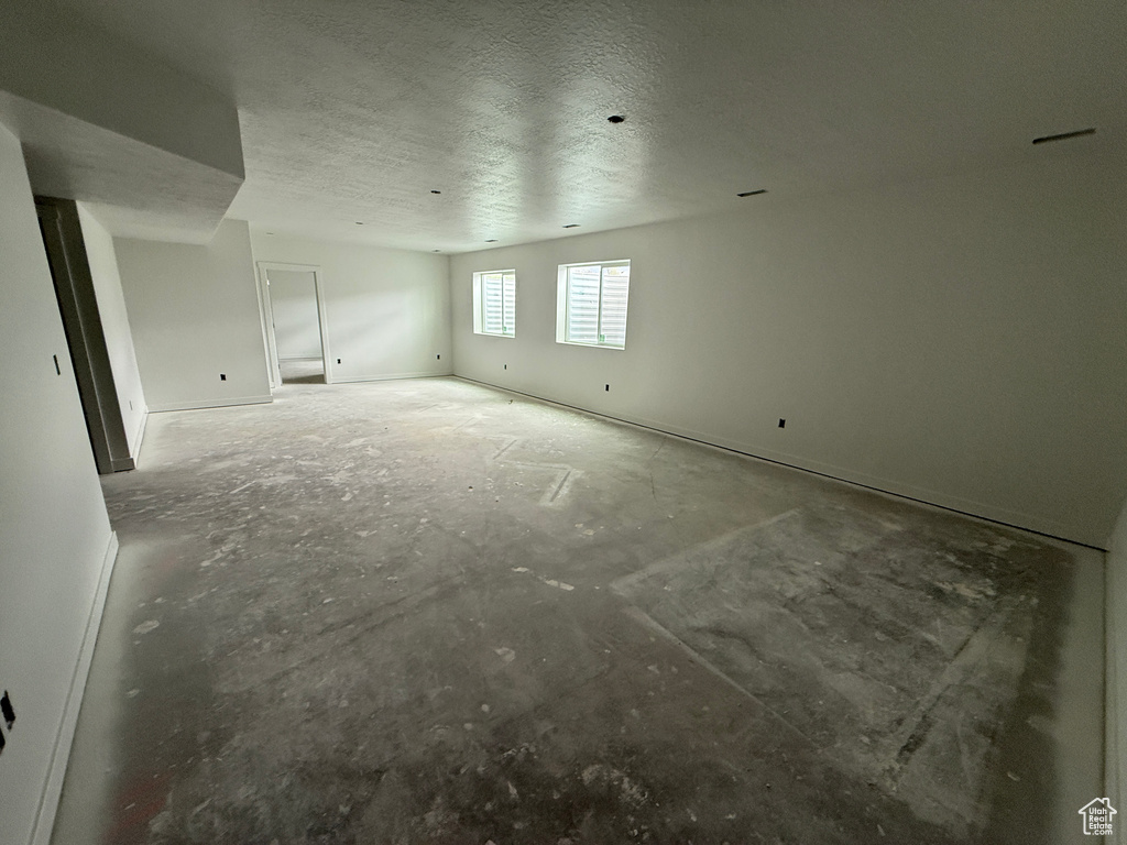 Spare room with a textured ceiling and baseboards