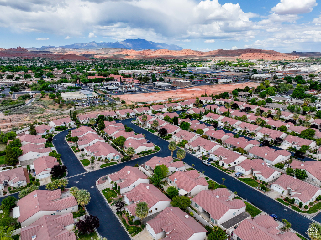 Aerial view of property and surrounding area with a mountainous background and nearby suburban area