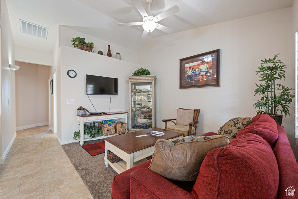 Living area featuring ceiling fan, light tile patterned floors, and baseboards