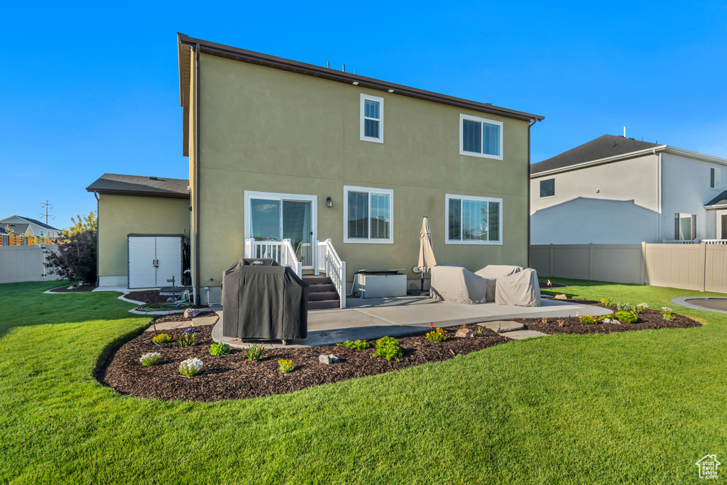 Back of property with stucco siding and a patio