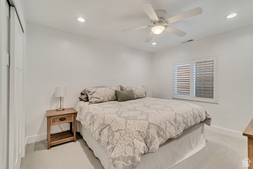 Bedroom with baseboards, a closet, light carpet, recessed lighting, and a ceiling fan