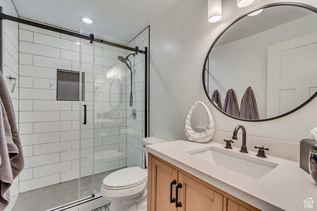 Full bath with toilet, a stall shower, and vanity