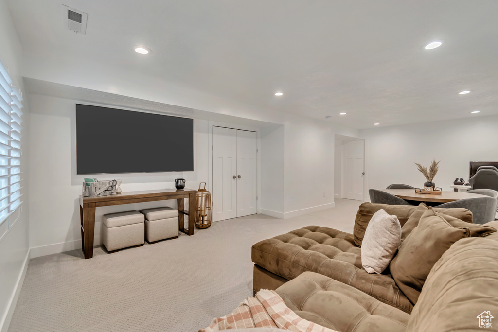 Carpeted living area with baseboards and recessed lighting